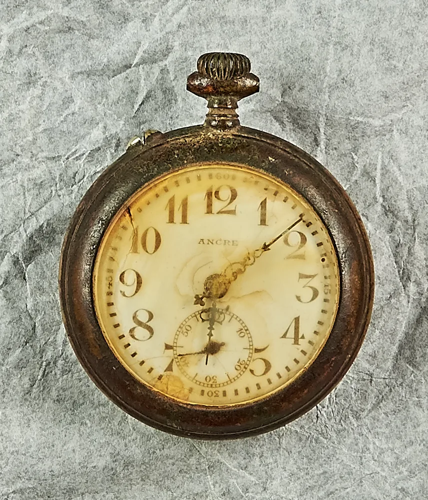 Die Taschenuhr von Albert Wirz, die er bis zuletzt auf sich trug. Man sieht eine alte, verrostete Taschenuhr.